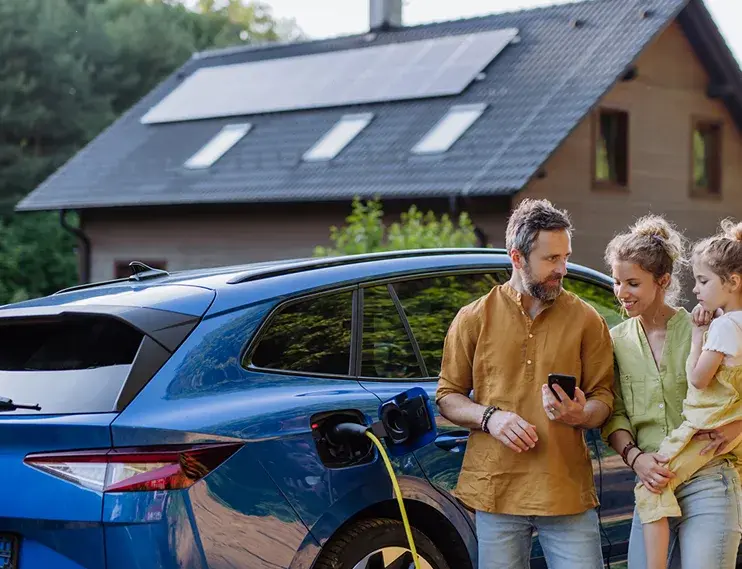 Man, woman and child inspecting their cost savings by having their own EV charger charging their electric car.